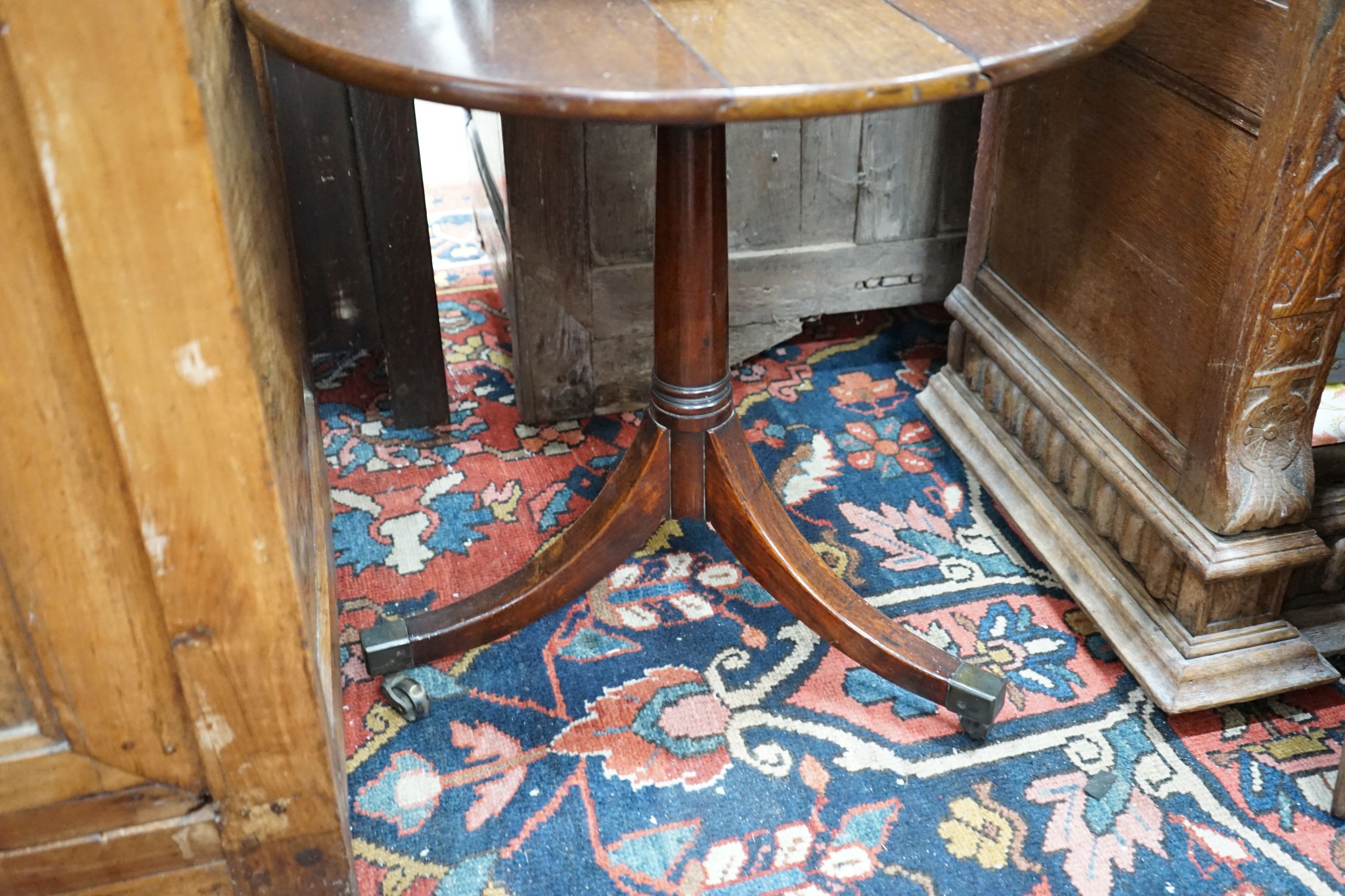 A George III circular mahogany two tier drop flap dumb waiter, height 97cm